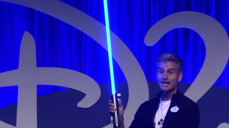 Josh D'Amaro, Chairperson of Disney Parks, Experiences and Products, shows his lightsaber