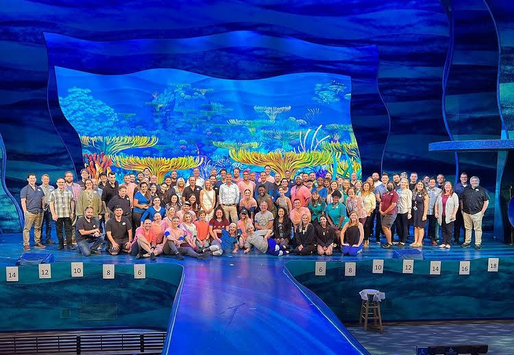 The assembled cast and crew of the new Finding Nemo musical on stage in the theater in the wild at Disney's Animal Kingdom.